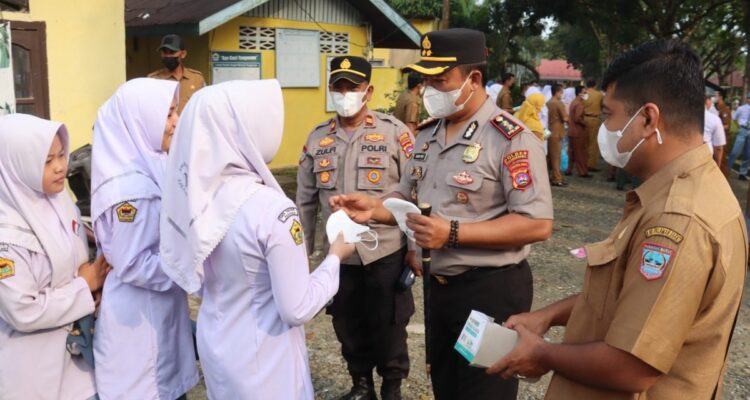 Kapolres Pasaman Barat membagikan masker medis kepada pelajar SMA Negeri 1 Pasaman untuk antisipasi dampak kabut asap.