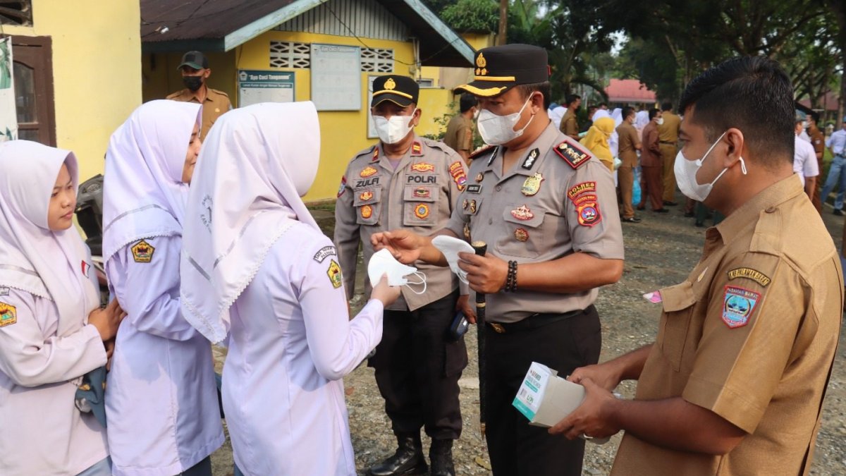 Kapolres Pasaman Barat membagikan masker medis kepada pelajar SMA Negeri 1 Pasaman untuk antisipasi dampak kabut asap.